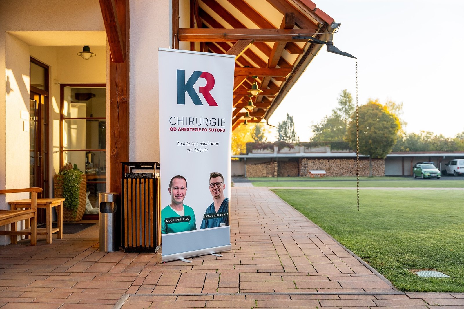 Lékaři u roll-up banneru KR Chirurgie od anestezie po suturu před školicím areálem
