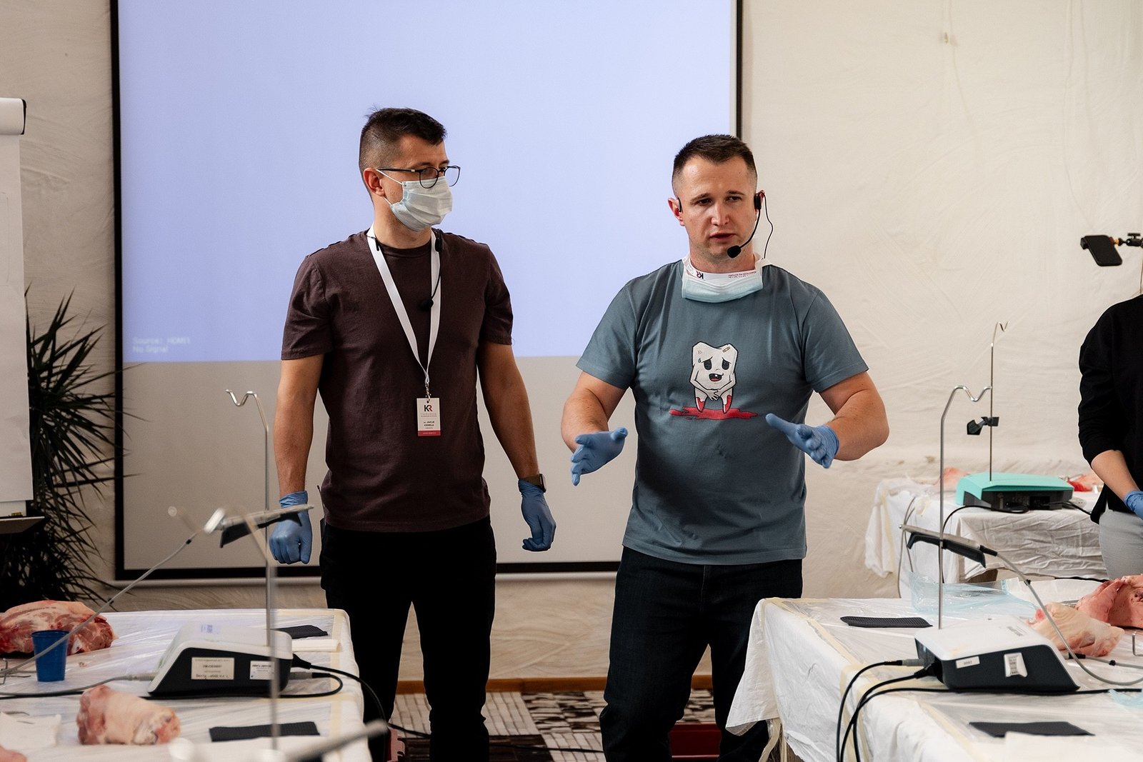 Hands-on výcvik – oba lektoři v rukavicích u pracovních stolů s preparáty